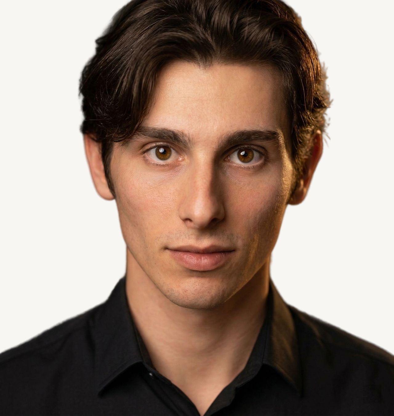Tristan Colt. Tristan Colt looking straight into the camera with a calm, confident expression, dark hair swept back, black shirt.